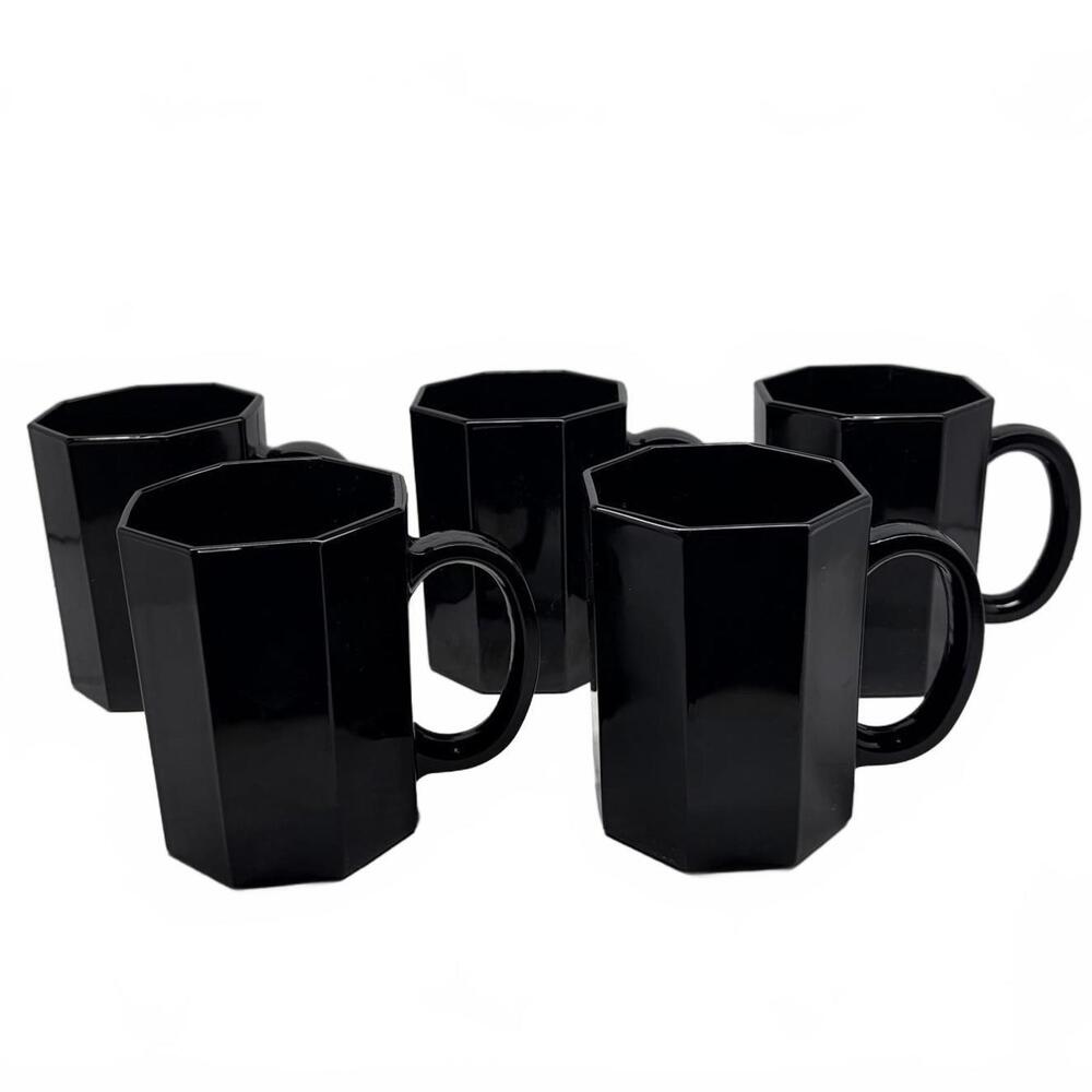 Set of five black glass Arcoroc Octime octagonal mugs.